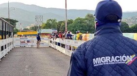 Fotografía de oficial de Migración Colombia de espalda
